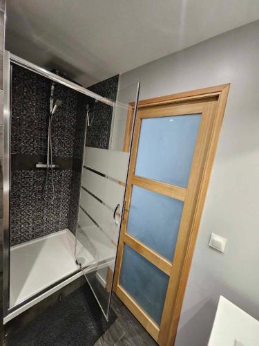 a shower with a glass door in a bathroom at Le clapotis des flots in Calais