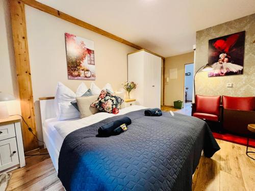 a bedroom with a large bed and a red chair at AyCatcherHomes - Top Lage I Zentral I Altstadt Marburg I Nähe Fluss Lahn I WLAN I Boutique Apartment NOVA in Marburg an der Lahn