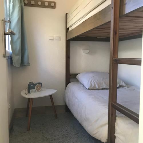 une chambre avec un lit superposé et une table avec un réveil dans l'établissement Appartement La Croix Valmer, Golfe de Saint Tropez, à La Croix-Valmer