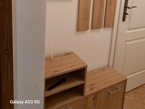 a wooden cabinet next to a door in a room at Noclegi "LAS WYPAS" Trzcianka in Trzcianka