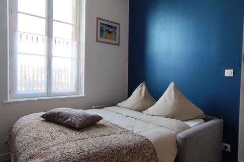 - un lit dans une chambre bleue avec un oreiller dans l'établissement HUBLOT Studio vue port, au Tréport