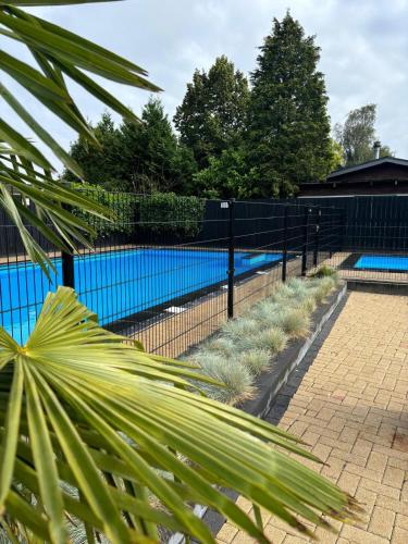 a black fence with a pool in the background at Ruim familie chalet tot 4 personen op de Veluwe Bungalowpark De Kern in Putten