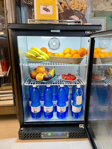 a refrigerator filled with bottles of water and fruit at Hostal Boutique Olvido 22 Adults Only in Peñíscola