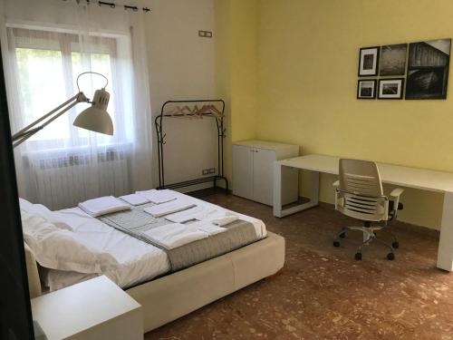 a bedroom with a bed and a desk and a chair at Forconium in LʼAquila