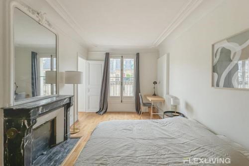 Cette chambre blanche dispose d'une cheminée et d'un lit. dans l'établissement Flexliving - room - Turbigo, à Paris