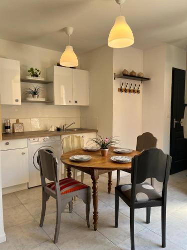 une cuisine avec une table en bois et deux chaises dans l'établissement Petite pause à Beauvais, à Beauvais