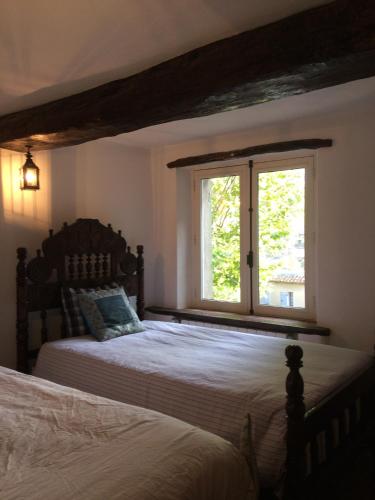 une chambre avec deux lits et une fenêtre dans l'établissement La Sanglière, à Ampus