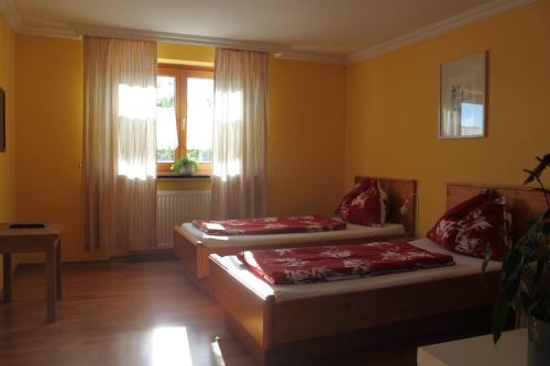 two beds sitting in a room with a window at Gästehaus Braunegger in Lamprechtshausen