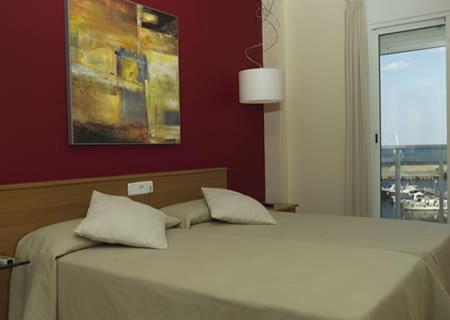 a bed with two pillows on it in a bedroom at Hotel Roca Plana in L'Ampolla