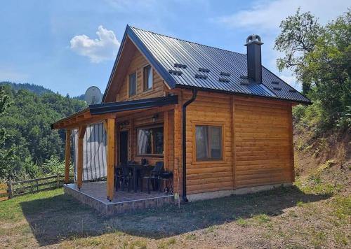 a log cabin with a porch and a table at Vila Bella, Tara, Zaovinsko jezero in Zaovine
