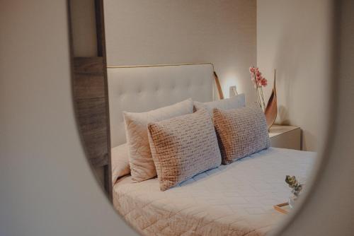 a mirror reflecting a bed with pillows on it at Amalurra Ecohotel & Retreat Center in Artzentales