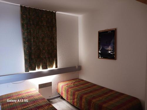 une petite chambre avec un lit et une fenêtre dans l'établissement Résidence Ruitor Arc 1800 - Appartement 2 pièces 5 personnes avec une belle vue sur la vallée, proche du télécabine dans le village de Charmettoger à Arc 18 MAE-1729, à Arc 1800