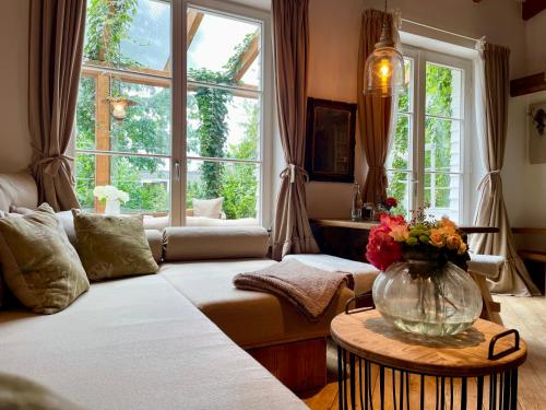 a living room with a couch and a large window at Weißt Du noch - Gästehäuser & Suiten in Kühlungsborn