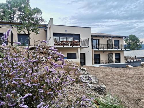 a house with purple flowers in front of it at Auberge de Planzolles in Planzolles