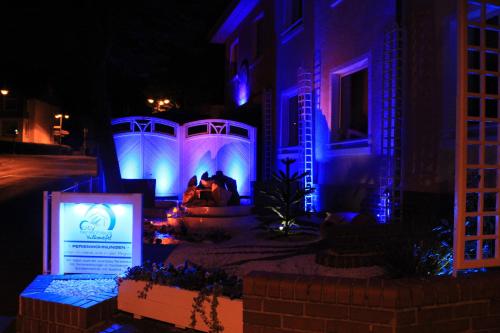 a house with blue and purple lights in a yard at Ferienwohnung Vulkaneifel in Daun