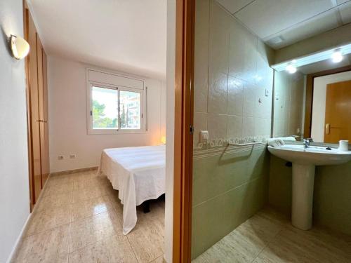 Un baño con una cama, un lavabo y un espejo. en Cala Beach, en Salou