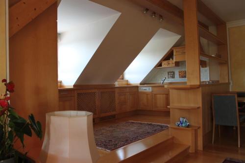 a large kitchen with wooden cabinets and a staircase at Gästehaus Braunegger in Lamprechtshausen