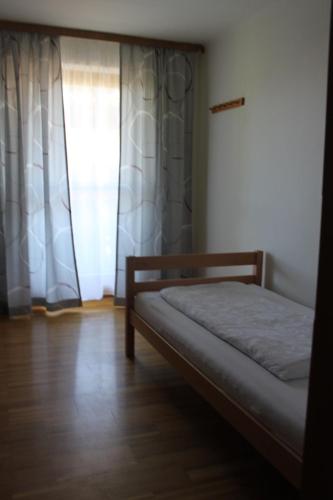a small bedroom with a bed and a window at Gästehaus Braunegger in Lamprechtshausen