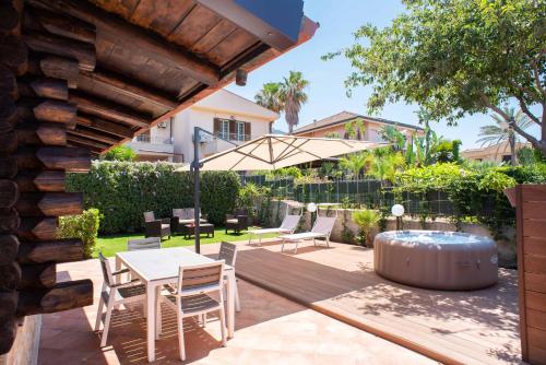 a patio with a table and chairs and an umbrella at Chalet Seaview by AR Group Hotels in Isola delle Femmine