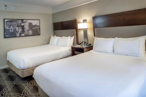 two beds in a hotel room with white pillows at St. Louis Union Station Hotel, Curio Collection by Hilton in Saint Louis