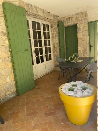 un patio avec des portes vertes et un seau jaune dans l'établissement Appartement avec terrasse 3 personnes Via Romana Vaison la Romaine, à Vaison-la-Romaine