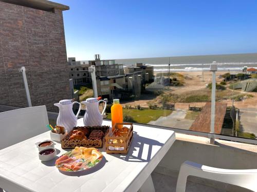 een tafel met eten en uitzicht op het strand bij Zelena Voda in Villa Gesell