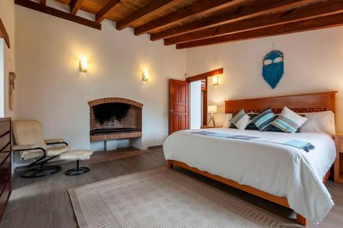 a bedroom with a large bed and a fireplace at Incredible Property with Huge Garden and Pool! in Valle de Bravo