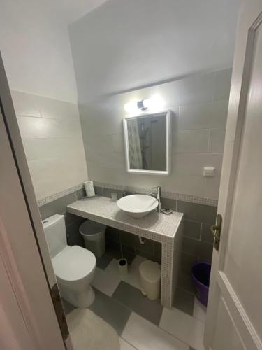 a bathroom with a toilet and a sink and a mirror at Maria's Room in Kamarai