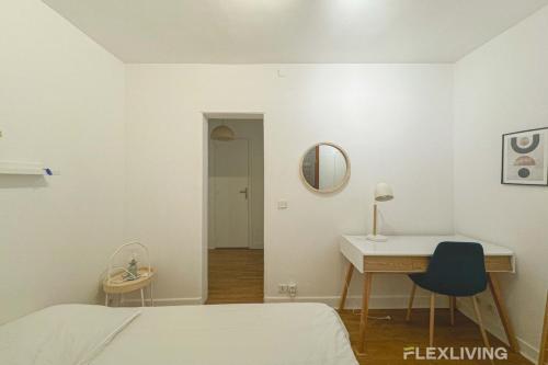 une chambre avec un lit, un bureau et un miroir dans l'établissement Flexliving - room - Banquier, à Paris