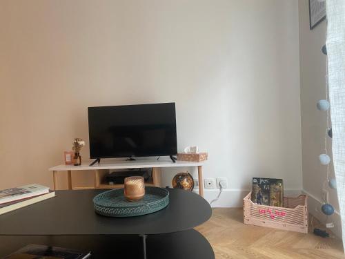 a living room with a table with a tv at La maison Eydel 2 à 4 voyageurs in Saint-Maurice