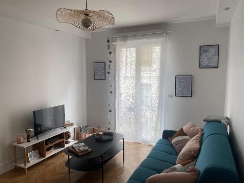 a living room with a blue couch and a table at La maison Eydel 2 à 4 voyageurs in Saint-Maurice