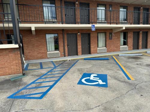a handicapped sign in a parking lot in front of a building at Royal Inn - Anniston in Anniston