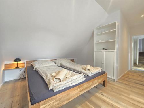 a bed with blankets on it in a room at Apartments Zur Bauerndiele " Lüttje Stuuv" in Hage