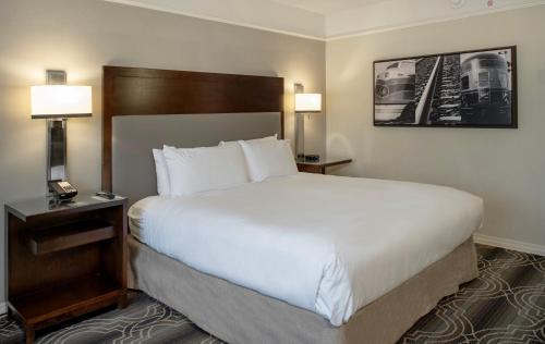 a hotel room with a large bed and two lamps at St. Louis Union Station Hotel, Curio Collection by Hilton in Saint Louis