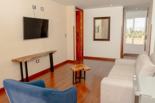 a living room with a couch and a tv at Samakwā Hotel Boutique in Paipa