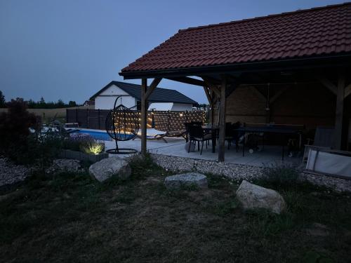 a gazebo with a table and chairs in a yard at Koniec Świata Stare Sady apartament in Mikołajki