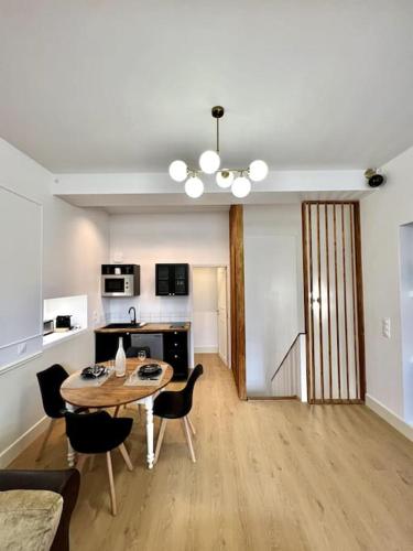 un salon avec une table et des chaises et une cuisine dans l'établissement Le Margaux Balnéo spacieux calme, à Conques-sur-Orbiel