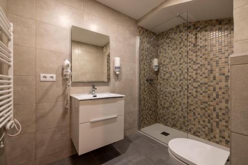 Un baño con inodoro, lavabo y ducha. en Estudio Para Grupos Pequeños en El Pas De La Casa - Céntrico, en Pas de la Casa