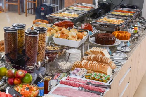 a buffet line with many different types of food at Hotel Plaza Garden in Cascavel