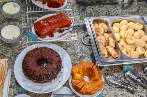a table topped with different types of pastries and cakes at Hotel Plaza Garden in Cascavel