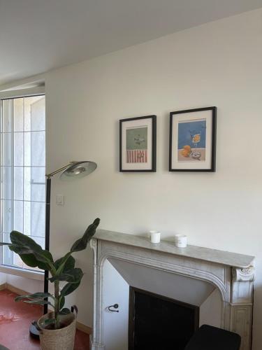 un salon avec une cheminée et trois photos sur le mur dans l'établissement Appartement Château Rouge, à La Londe-les-Maures