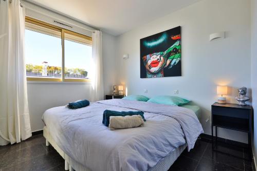 une chambre avec un grand lit avec une grande fenêtre dans l'établissement Centre St Tropez - 2 Pièces -Clim Piscine Parking, à Saint-Tropez