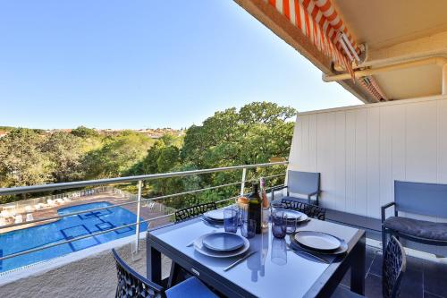 d'une table et de chaises sur un balcon avec piscine. dans l'établissement Centre St Tropez - 2 Pièces -Clim Piscine Parking, à Saint-Tropez
