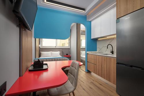 a kitchen with a red table and a bed at ARETOUSA old town SUITE in Heraklio Town
