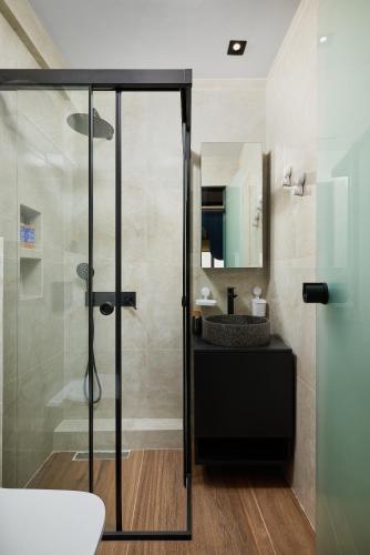 a bathroom with a glass shower and a sink at ARETOUSA old town SUITE in Heraklio