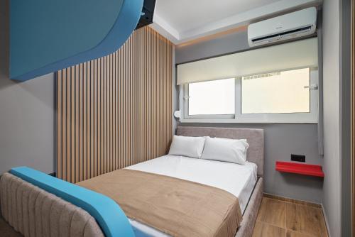a small bedroom with a bed and a window at ARETOUSA old town SUITE in Heraklio Town