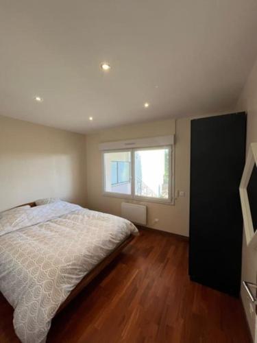 une chambre avec un grand lit et une fenêtre dans l'établissement Appartement T3 proche de paris super pour les JO, à Herblay