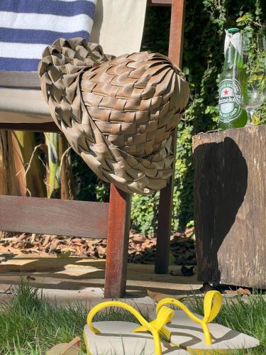 a bird statue sitting in the grass next to a bench at Kûara Pipa in Pipa