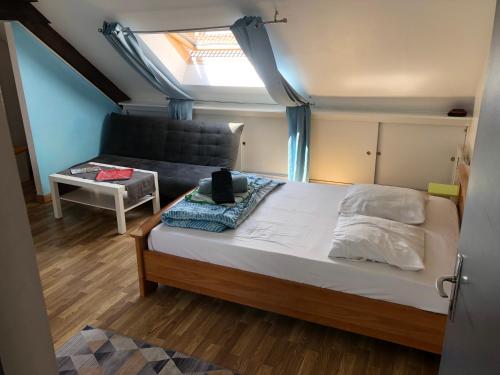 une petite chambre avec un lit et un canapé dans l'établissement Studio proche de la plage, à Dunkerque