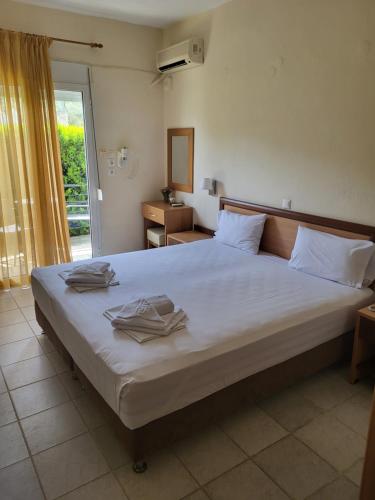 a bedroom with a large bed with towels on it at Vourvourou Hotel in Vourvourou